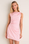 Woman in a classic, pink Tulip Callie Mini Dress with a high neckline and asymmetrical hem, showcasing effortless style. Perfect for fun, high-end occasions.