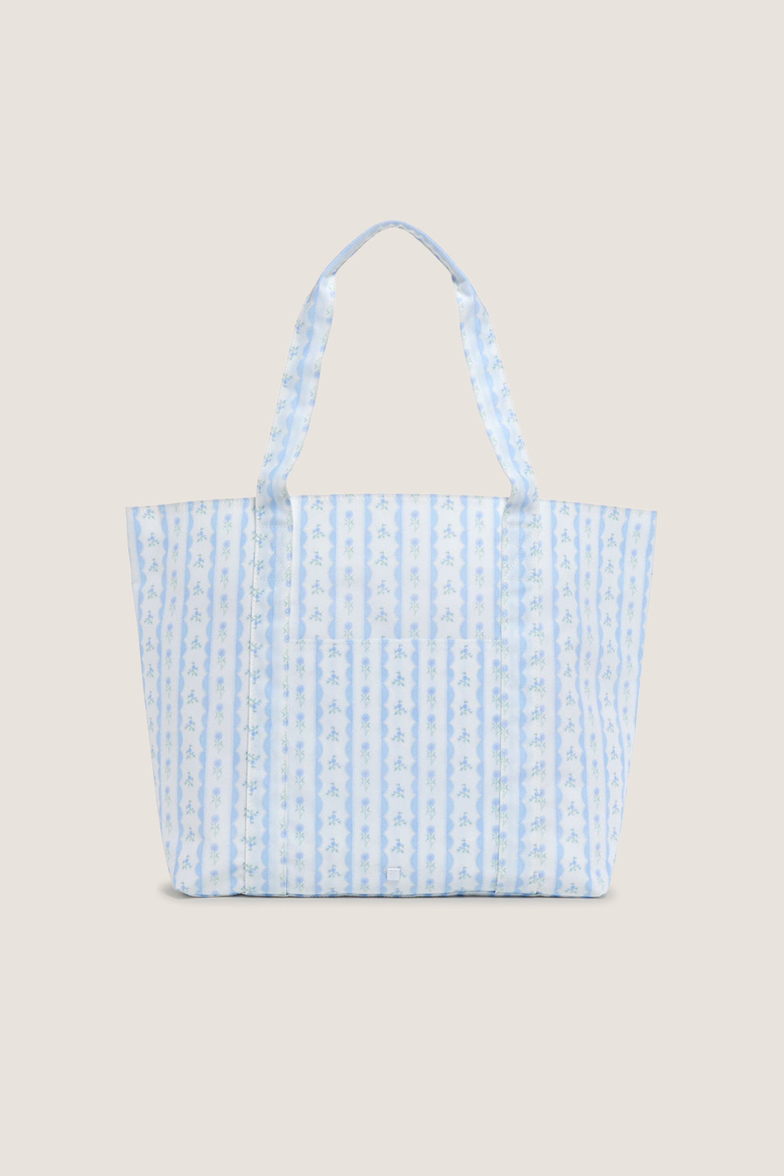 Floral Blue Ribbon Jumbo Tote features classic blue-and-white stripes with floral motifs, offering an effortless, high-end touch to your fun, everyday carry-all needs.