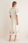 Back view of woman in classic, high-end Multi Astrid Embroidery Short Sleeve Midi Dress with puffed sleeves, colorful embroidery, and gathered skirt, embodying effortless and fun style.