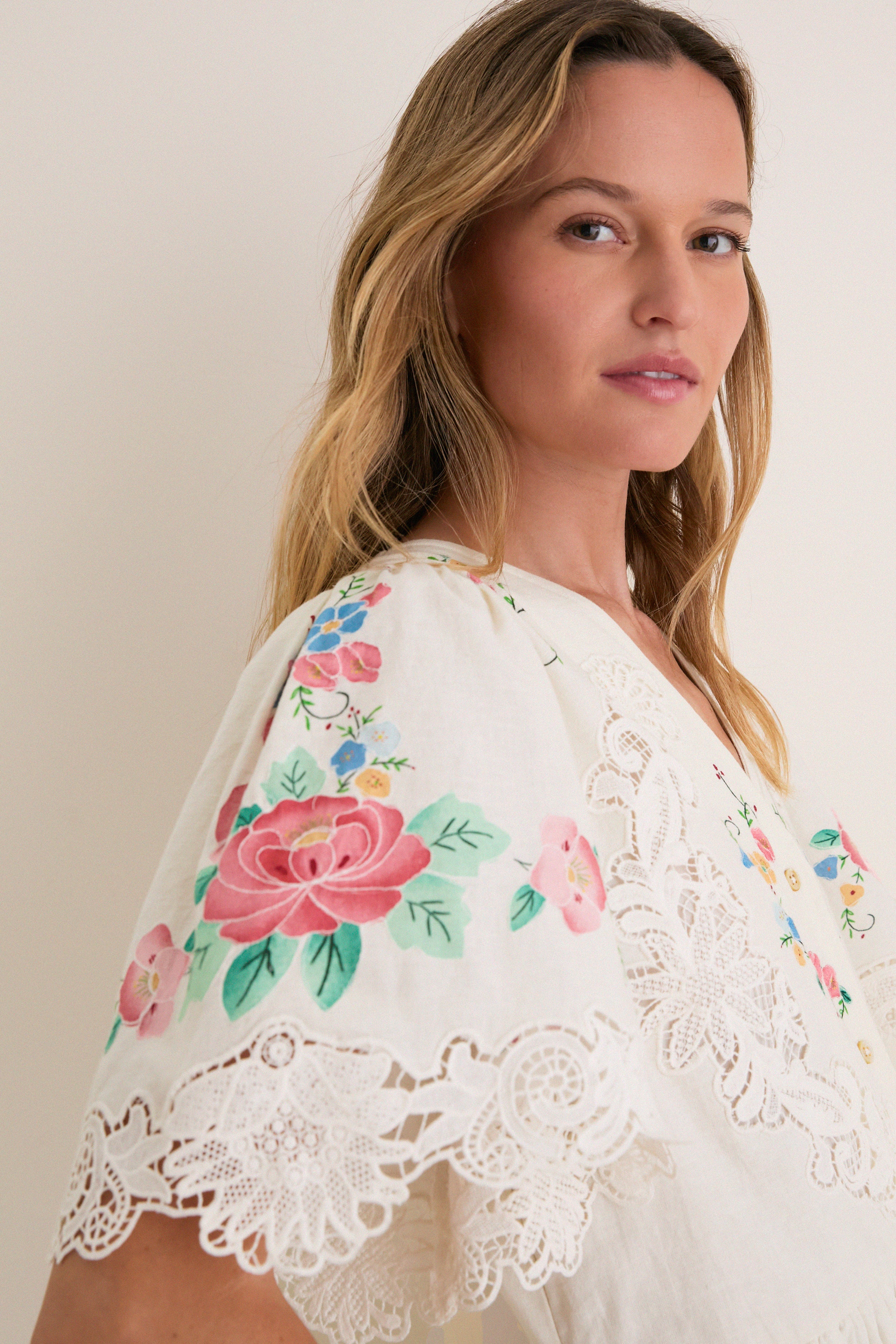 Young woman models the Multi Astrid Embroidery Short Sleeve Midi Dress, featuring a classic, high-end design with hand-painted floral details and delicate lace trim, epitomizing effortless elegance.