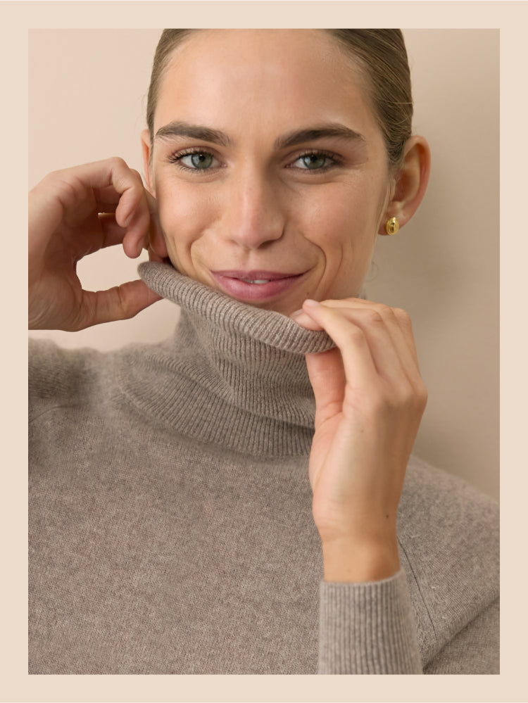 Woman in a wheat sweater dress with a turtleneck. 
