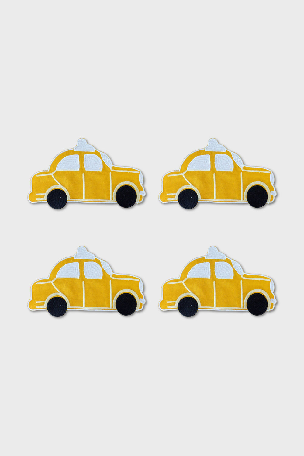 Four yellow cartoon-style taxi car illustrations, inspired by NYC coaster designs from Chefanie, are arranged in a two-by-two grid on a plain white background.