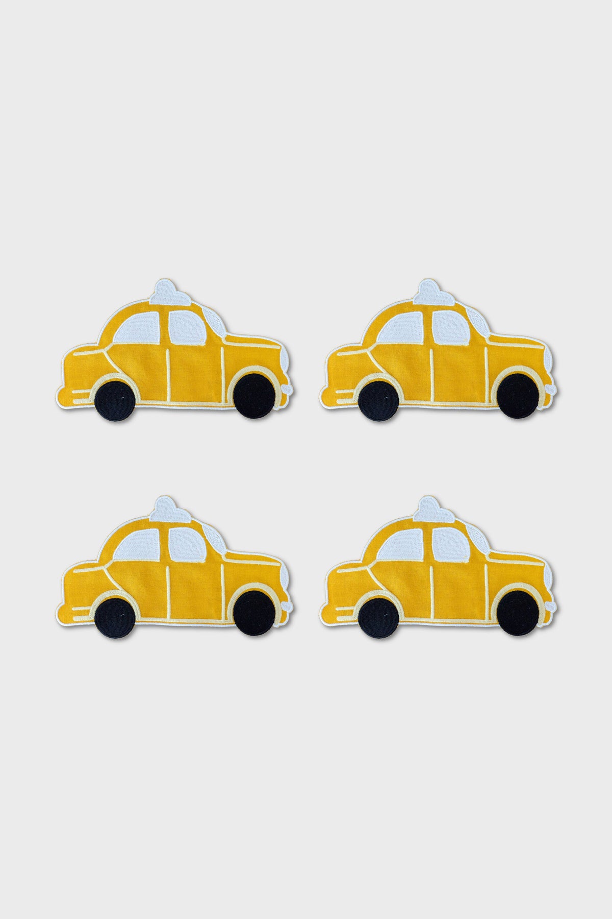 Four yellow cartoon-style taxi car illustrations, inspired by NYC coaster designs from Chefanie, are arranged in a two-by-two grid on a plain white background.