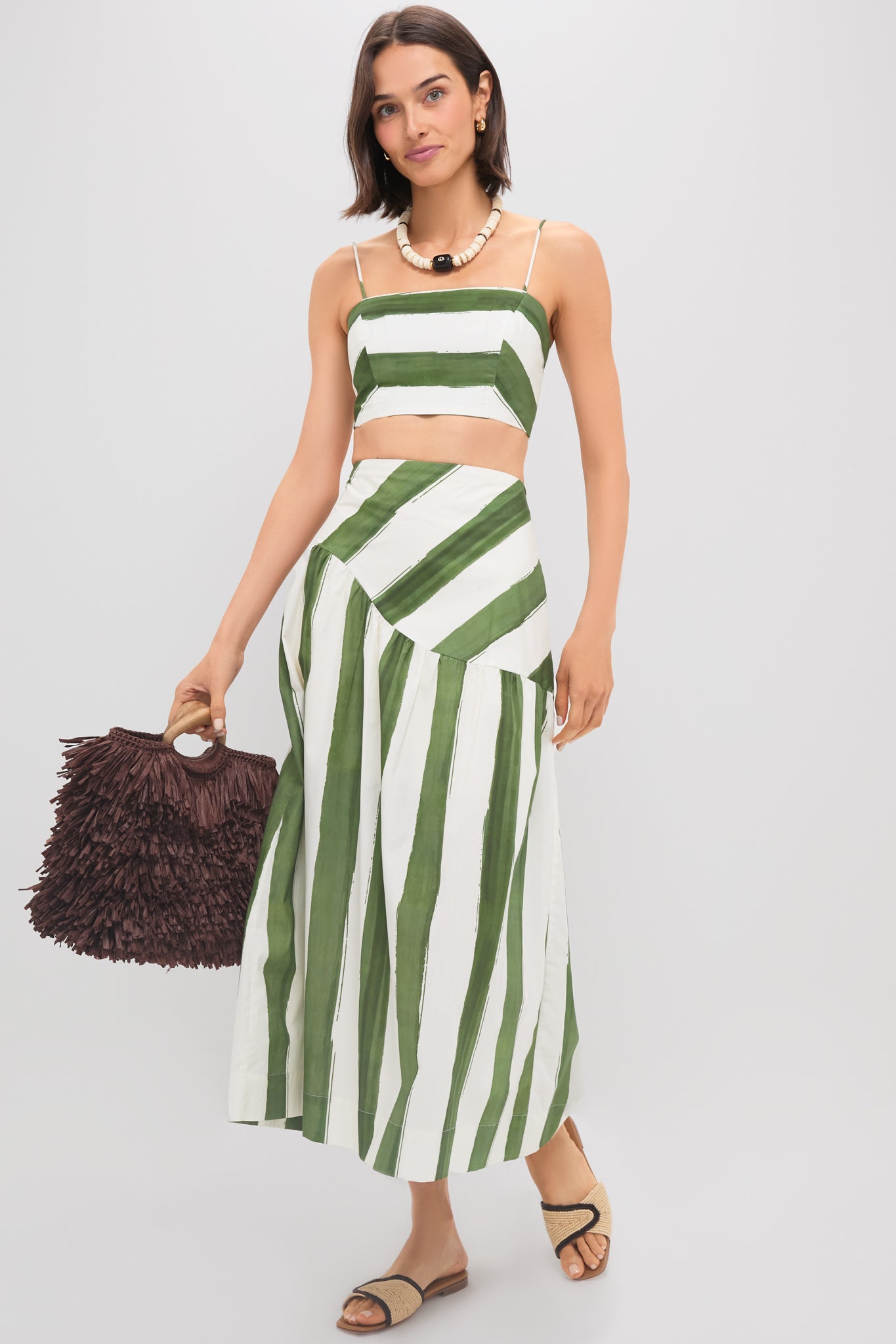 Woman in Green Stripe Nature Top with matching skirt, showcasing an effortless, high-end look with classic spaghetti straps, perfect for fun, last-minute getaways.