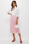 Woman wearing classic Soft Pink Shimmer Stripes Milan Midi Skirt, styled effortlessly with a crisp blouse and velvet mules; holding a beaded handbag for a fun, high-end look.