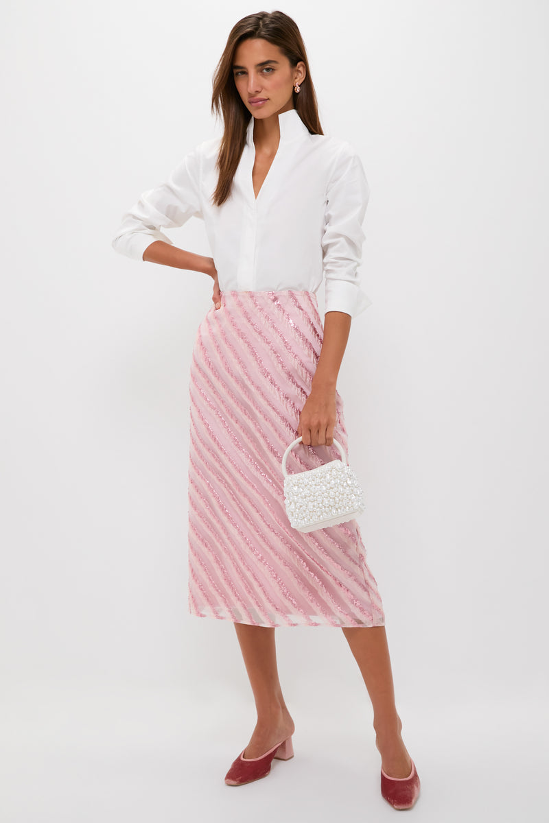 Woman wearing classic Soft Pink Shimmer Stripes Milan Midi Skirt, styled effortlessly with a crisp blouse and velvet mules; holding a beaded handbag for a fun, high-end look.