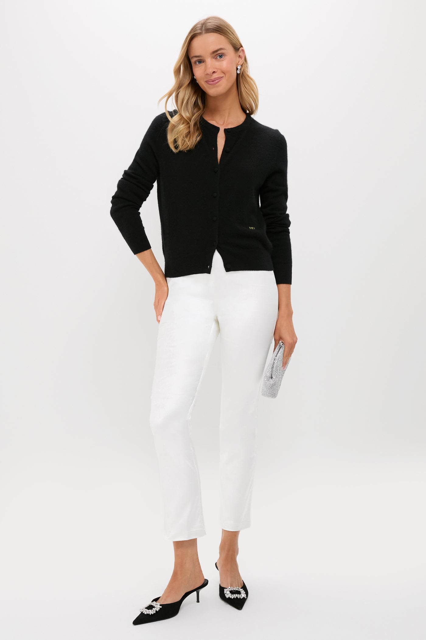 Woman models classic Winter White Velvet Ashford Pants, paired with an effortless black cardigan and high-end accessories, including kitten-heel mules and a rhinestone clutch.