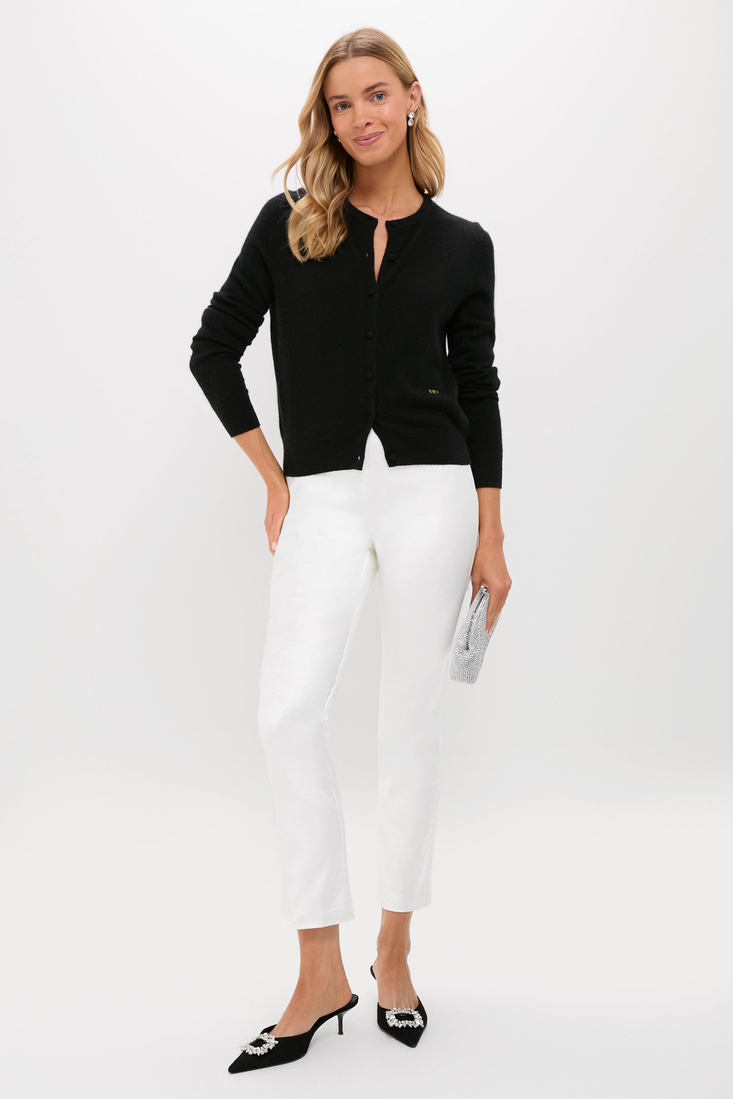 Woman models classic Winter White Velvet Ashford Pants, paired with an effortless black cardigan and high-end accessories, including kitten-heel mules and a rhinestone clutch.