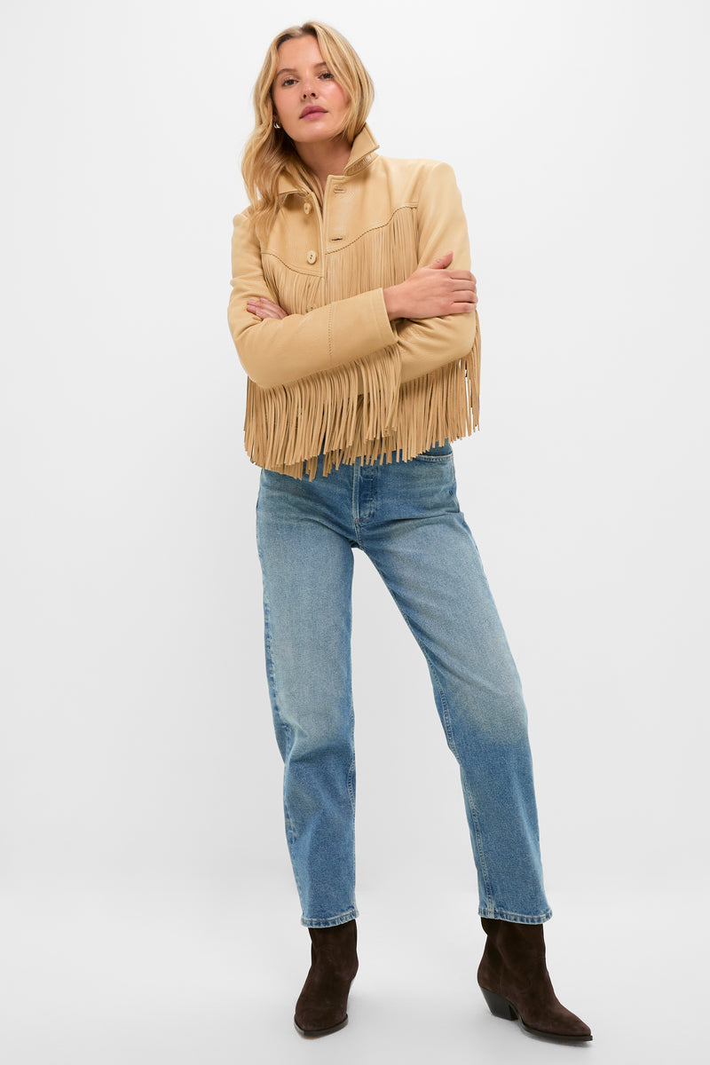 Woman wearing a classic, high-end Tan Deerskin Fringe Jacket with an effortless Western flair, paired with denim jeans and cowboy boots, embodying a fun, confident style.