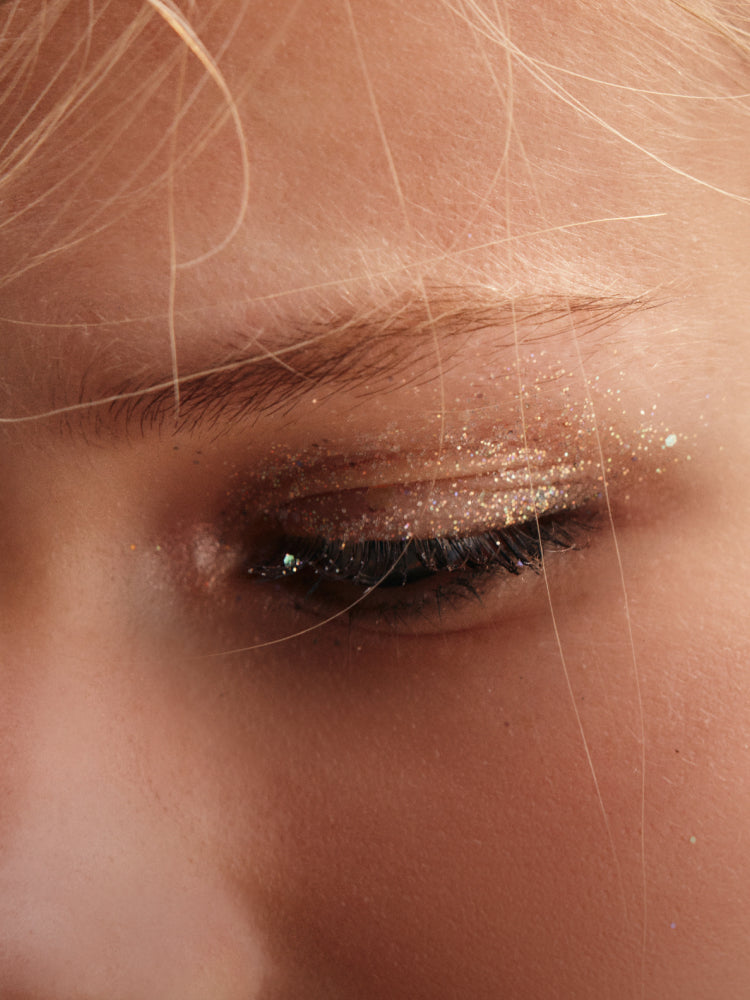 A close up shot of a woman's gold glitter eyeshadow.