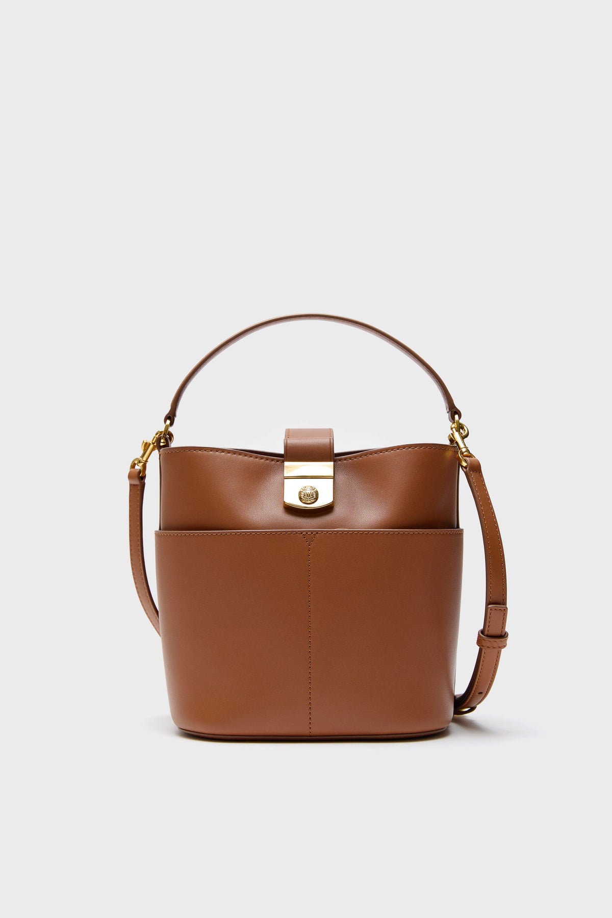 The Veronica Beard Hazelwood Small Bucket Bag features brown leather, a top handle, gold-tone clasp, and a removable shoulder strap for versatile style.