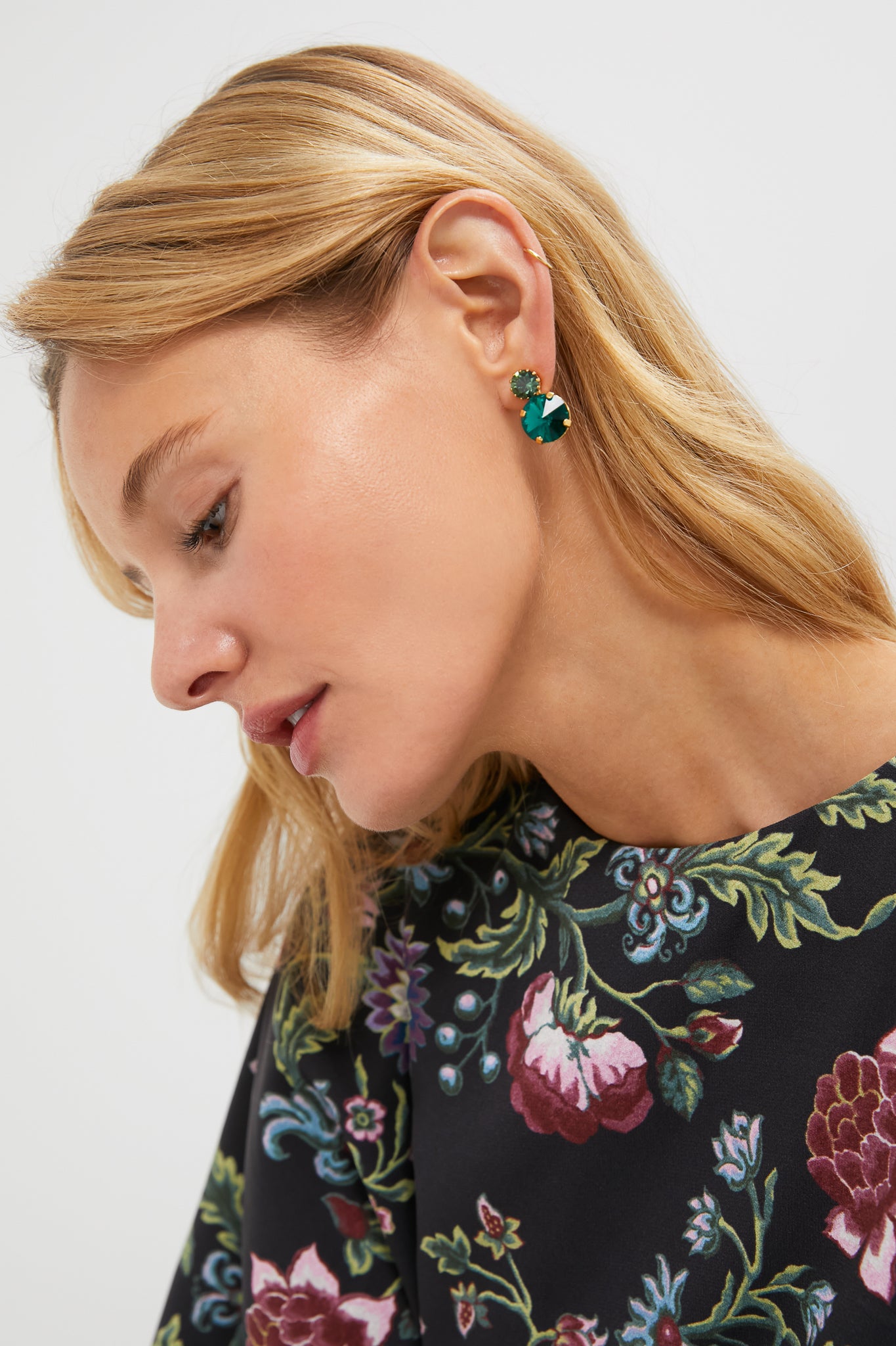 Close-up of a woman wearing the classic Emerald Myrla Earrings, featuring two green stones in a high-end, effortless design, perfect for fun, elevated style.