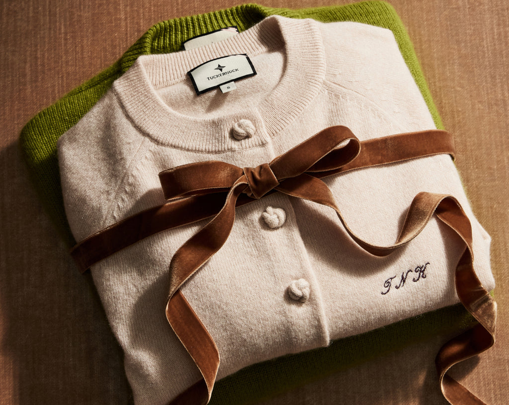 A stack of sweaters wrapped with a bow. 