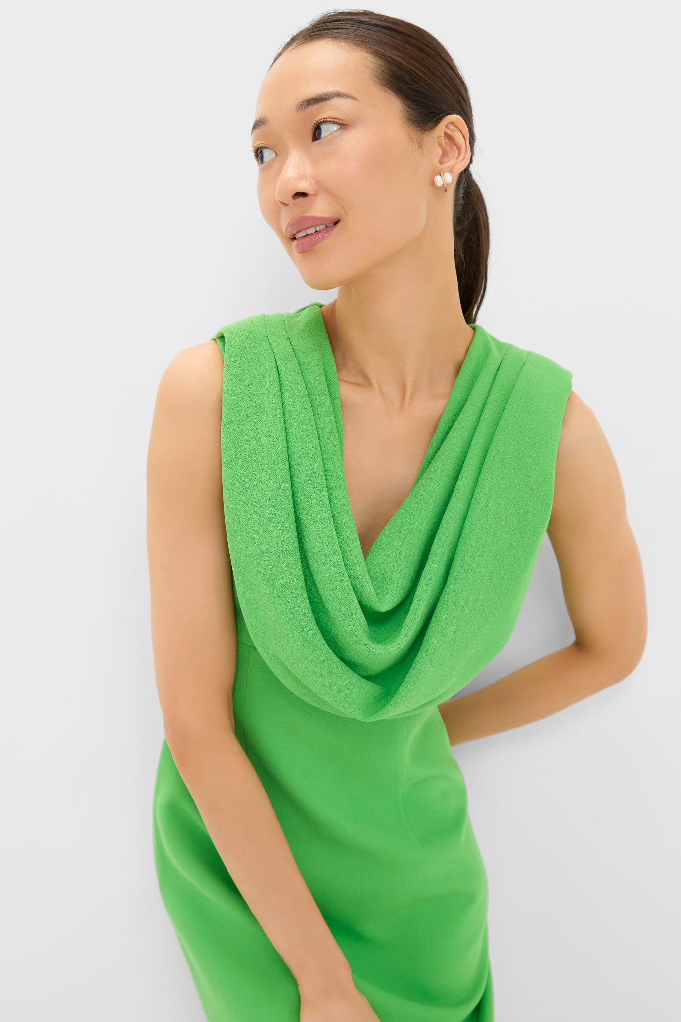 Woman in a bright green Yuri Gown with a cowl neckline, showcasing classic elegance. The dress features a tailored, high-end silhouette, perfect for effortless, fun styling.
