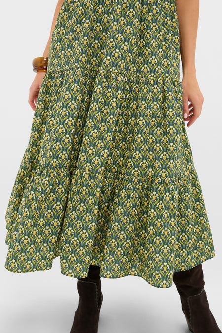 Forest Green Floral Bennett Maxi Dress showcasing a tiered midi skirt with yellow floral print, paired with dark boots and an amber bangle for a classic, effortless, high-end look.