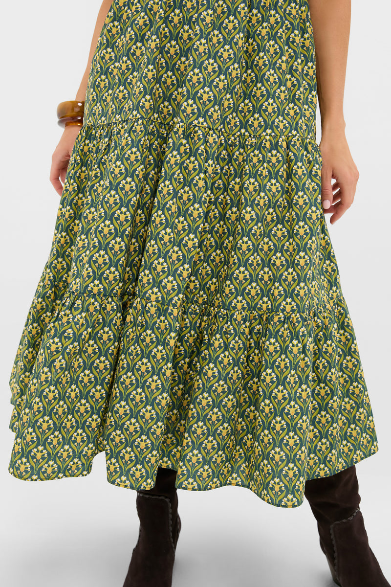 Forest Green Floral Bennett Maxi Dress showcasing a tiered midi skirt with yellow floral print, paired with dark boots and an amber bangle for a classic, effortless, high-end look.