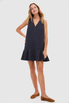 Effortless and classic, the Dark Slate Navy Flutter McKinney Mini Dress features a swing silhouette, V-neckline, and ruffled hem, paired with tan suede flats.