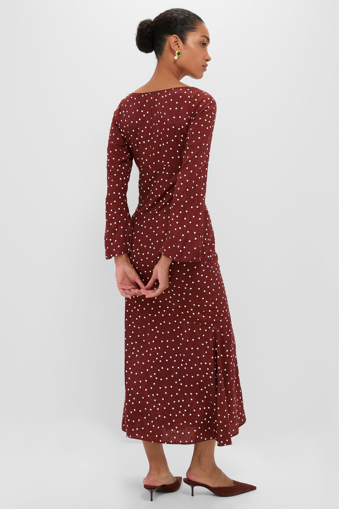 Woman in an effortless, classic Burnt Umber Narah Maxi Dress with chic polka dots, showcasing bell sleeves and a flattering silhouette, embodying high-end, fun sophistication.