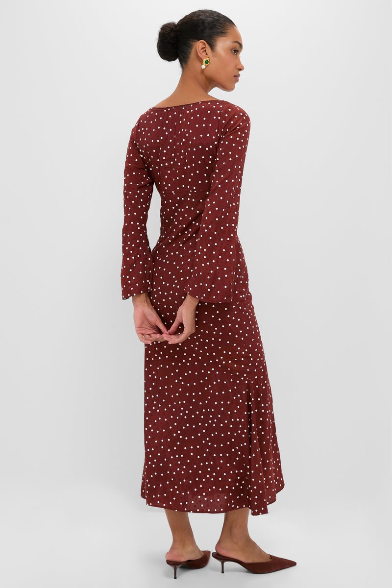 Woman in an effortless, classic Burnt Umber Narah Maxi Dress with chic polka dots, showcasing bell sleeves and a flattering silhouette, embodying high-end, fun sophistication.
