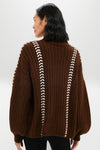 Classic Brown Mayu Sweater with contrasting white whip-stitch detailing, embodying effortless style and high-end craftsmanship, ideal for fun and chic winter layering.
