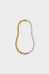 A coiled two-tone choker from Jenny Bird featuring one half in gold and the other in silver.