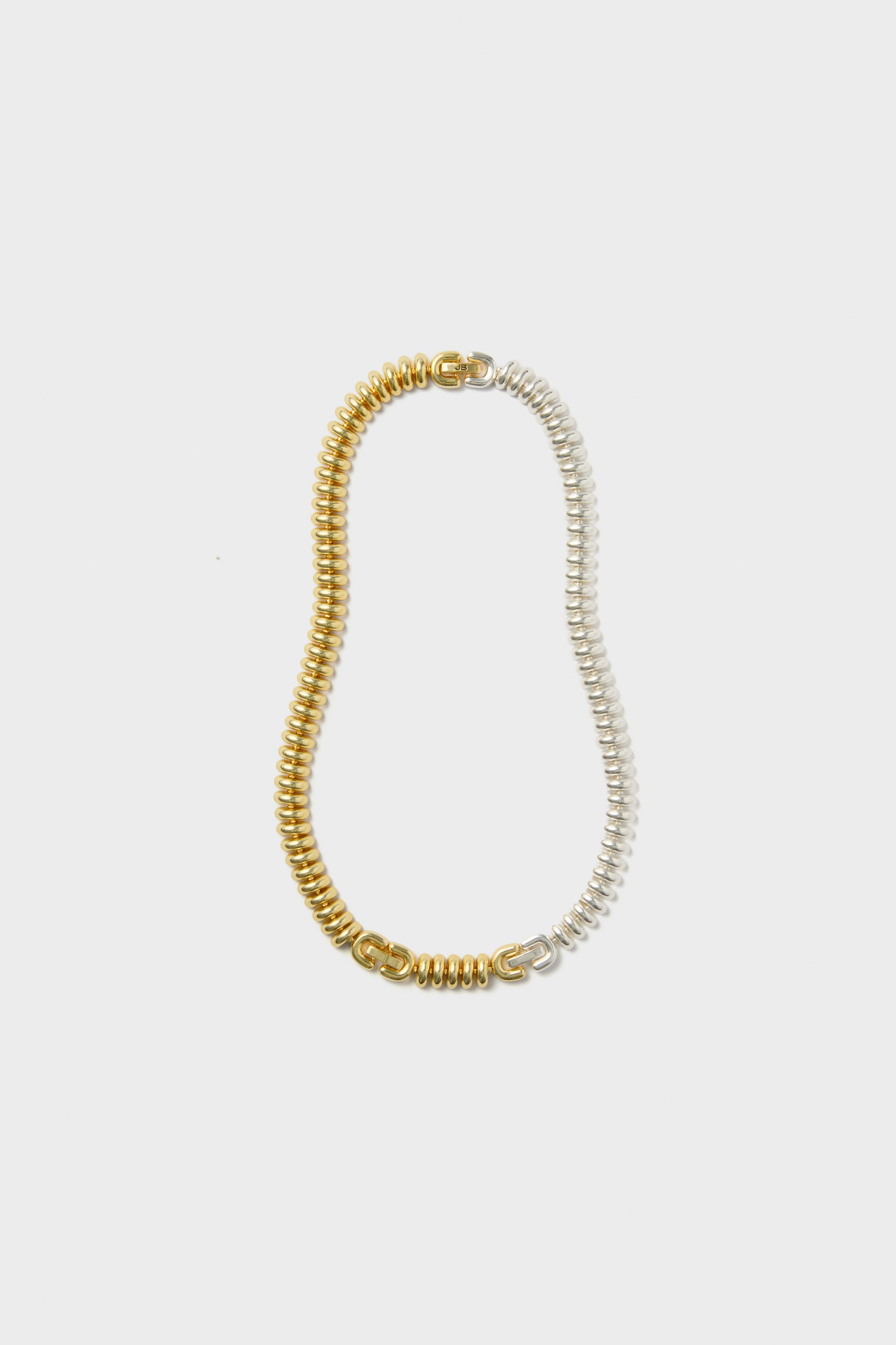 A coiled two-tone choker from Jenny Bird featuring one half in gold and the other in silver.