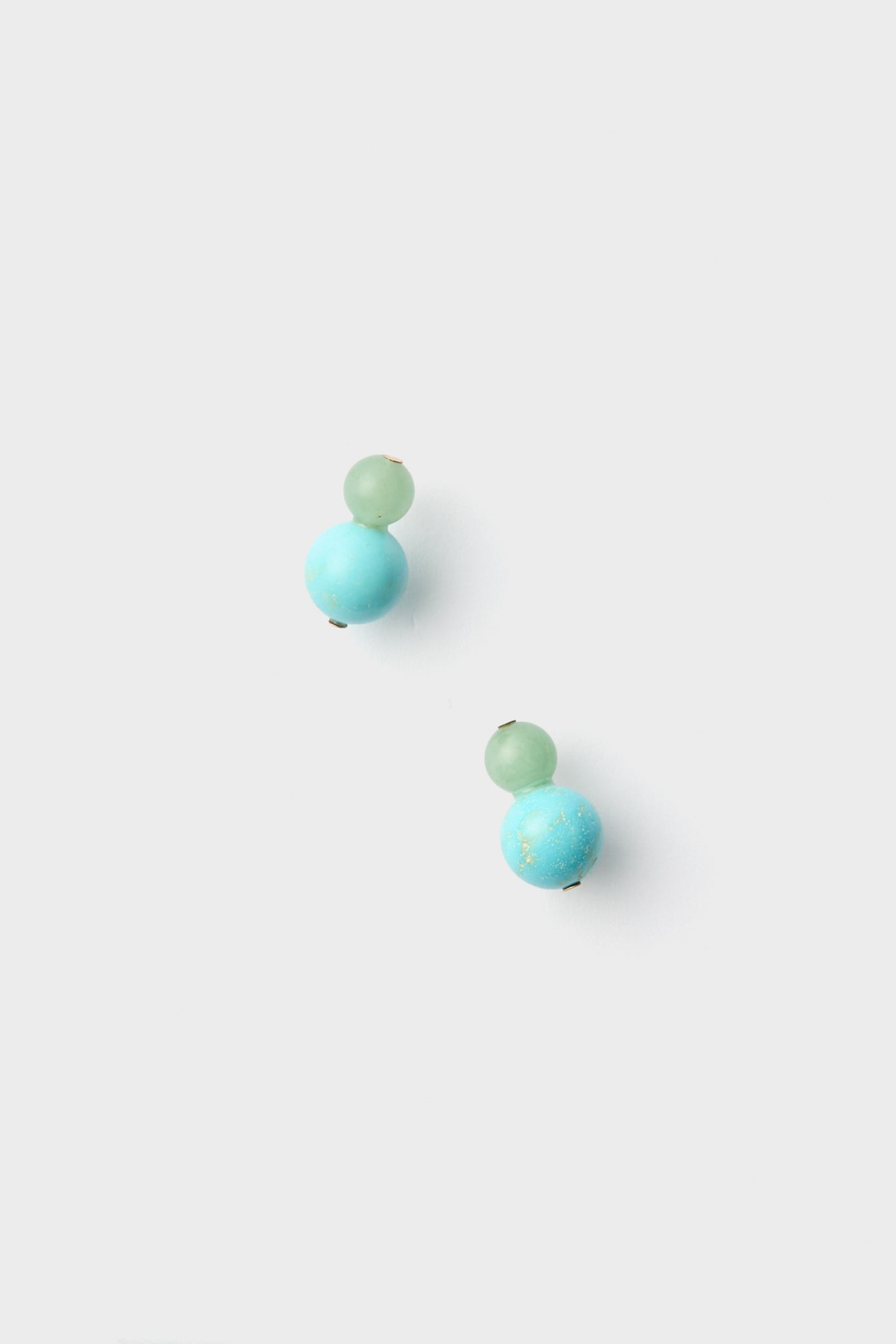 A pair of turquoise bead earrings, with one small aventurine bead and a larger bead on each nickel-free stud.
