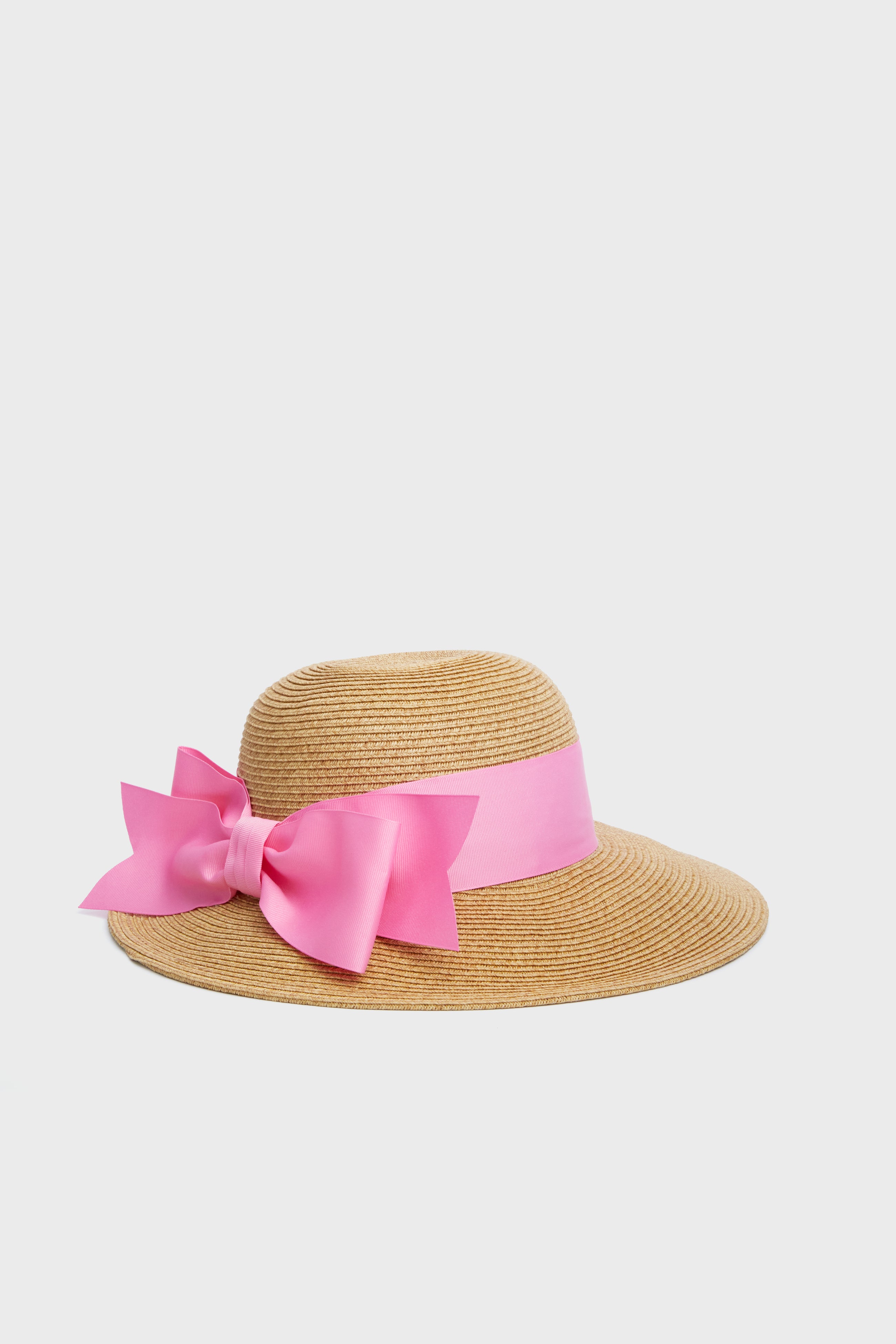 Toucan Hats wide-brimmed straw hat features a large pink ribbon and bow, making it a stylish, packable accessory for the beach or sunny days.