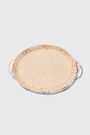 The AERIN round rattan tray features two side handles and raffia accents, adding a touch of coastal design.
