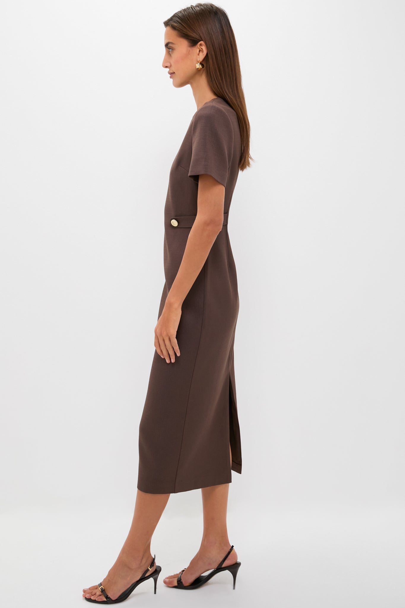 Model in Chocolate Brown Zarah Midi Dress, featuring gold button detail and back slit, paired with black slingback heels, epitomizing classic, effortless style for versatile, high-end dressing.