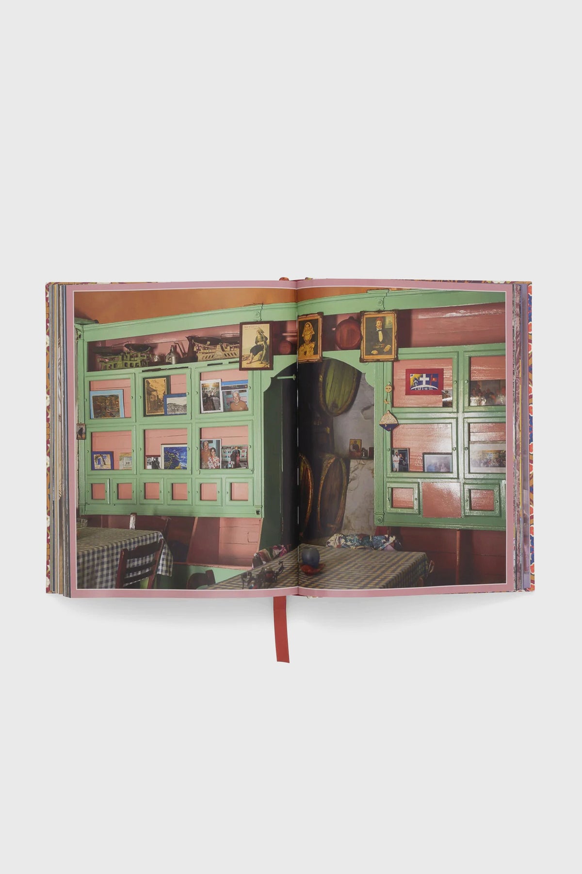 Cabana Anthology: The Anniversary Edition, featuring a vibrant café scene with green shutters and checkered tables, exudes classic, high-end design. Perfect for effortless, fun decor inspiration.