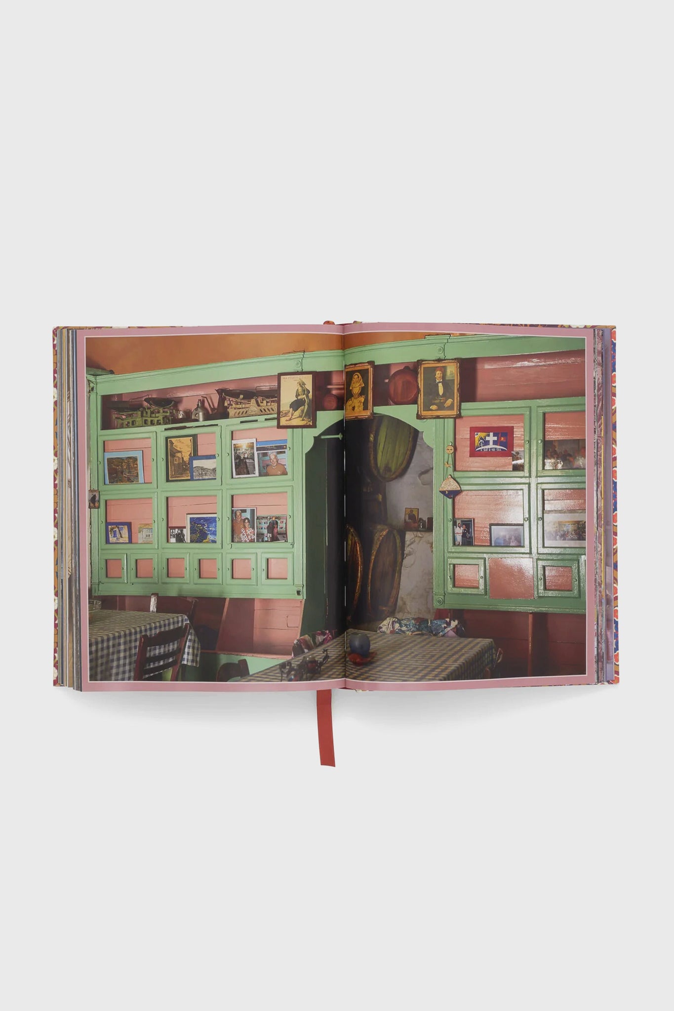 Cabana Anthology: The Anniversary Edition, featuring a vibrant café scene with green shutters and checkered tables, exudes classic, high-end design. Perfect for effortless, fun decor inspiration.