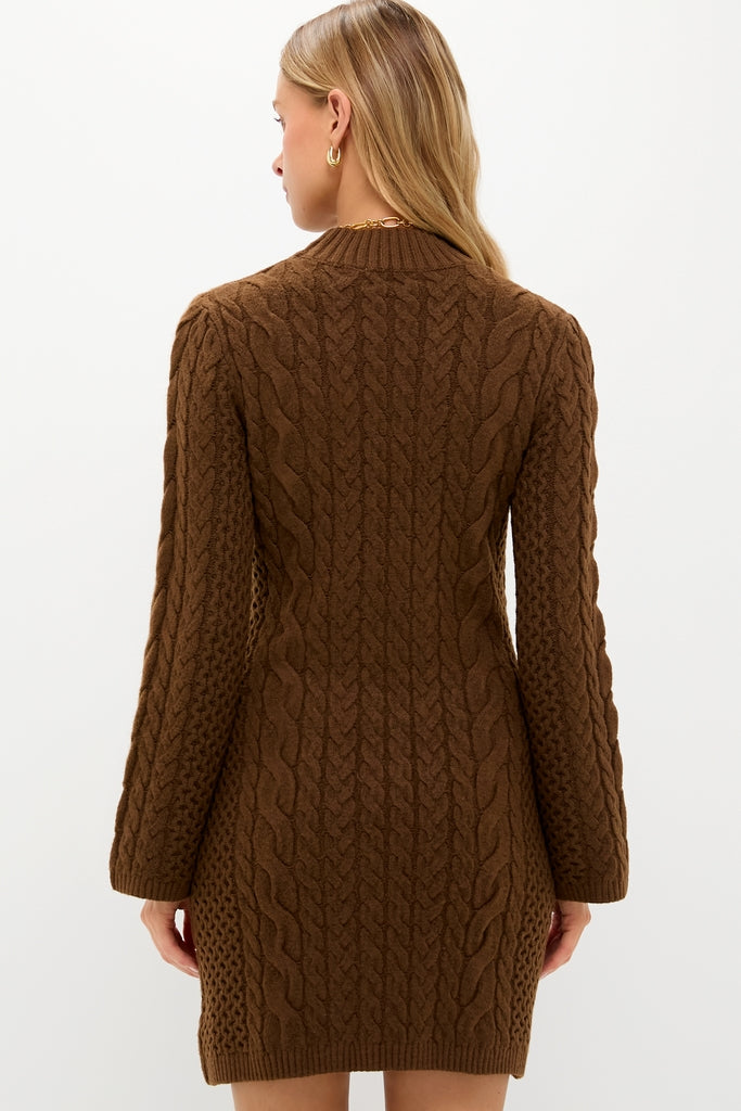 Back view of a model in a classic Coffee Cable Knit Lucia Mini Dress, showcasing long sleeves and a mock neck, paired with gold accessories for an effortless, high-end look.