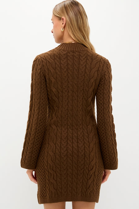 Back view of a model in a classic Coffee Cable Knit Lucia Mini Dress, showcasing long sleeves and a mock neck, paired with gold accessories for an effortless, high-end look.