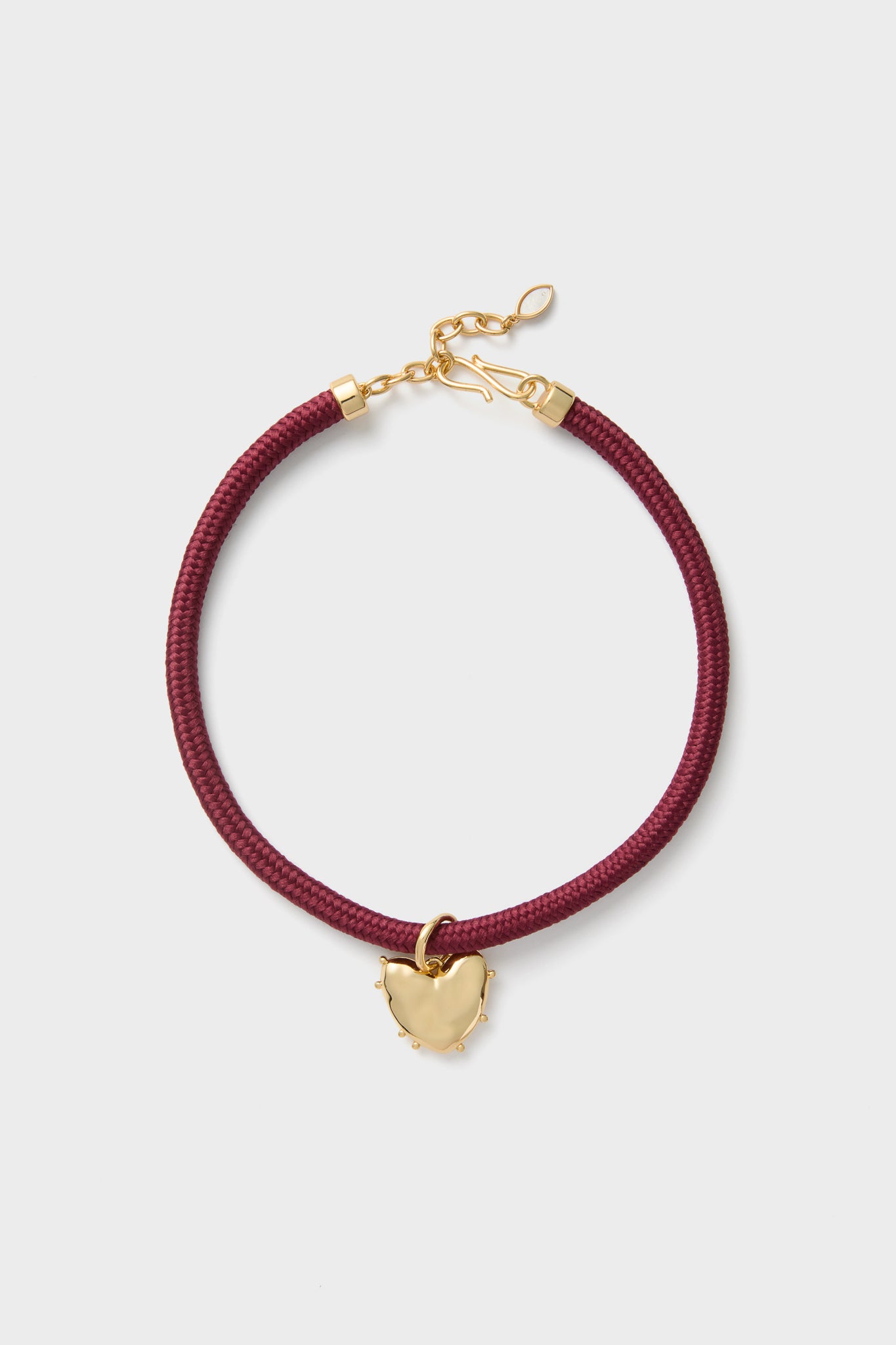 Maroon Lelani Necklace: A classic, high-end braided cord choker with an effortless gold heart charm and adjustable clasp, offering fun, versatile styling options.