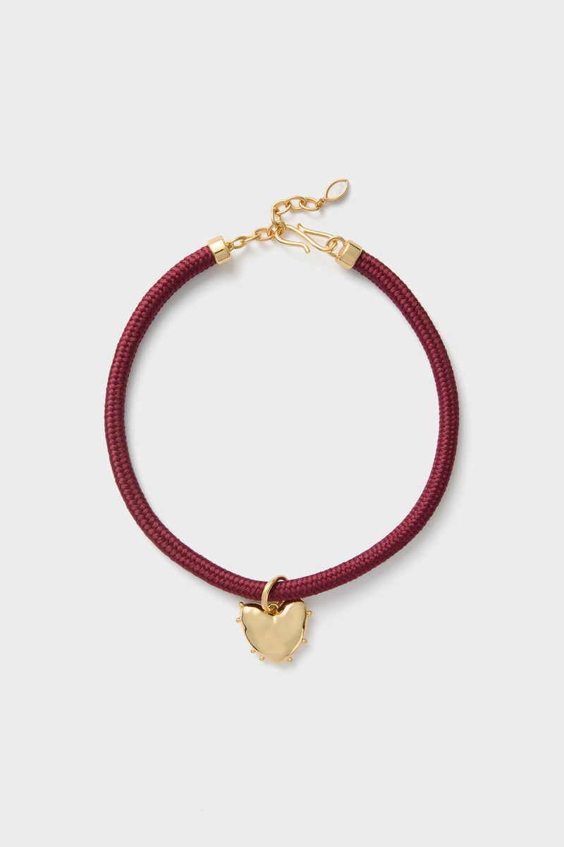 Maroon Lelani Necklace: A classic, high-end braided cord choker with an effortless gold heart charm and adjustable clasp, offering fun, versatile styling options.