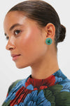 Woman wearing classic Malachite Emery Studs; round, gold-plated brass earrings with a green malachite center, perfect for an effortless, high-end look.