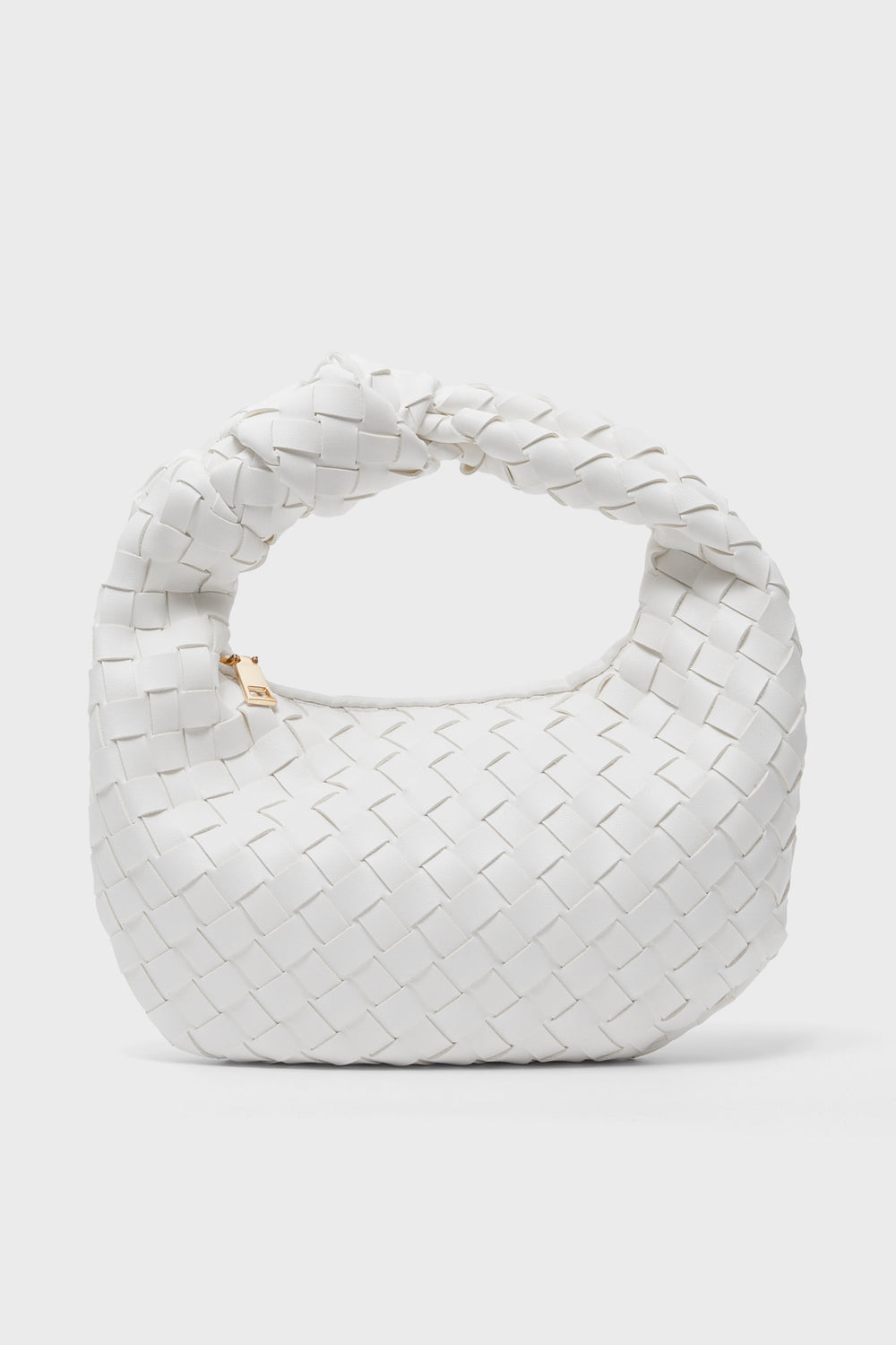 Urban Expressions presents a small white vegan handbag featuring a woven vegan leather texture and a twisted handle, displayed in an elegant, minimalist setting.
