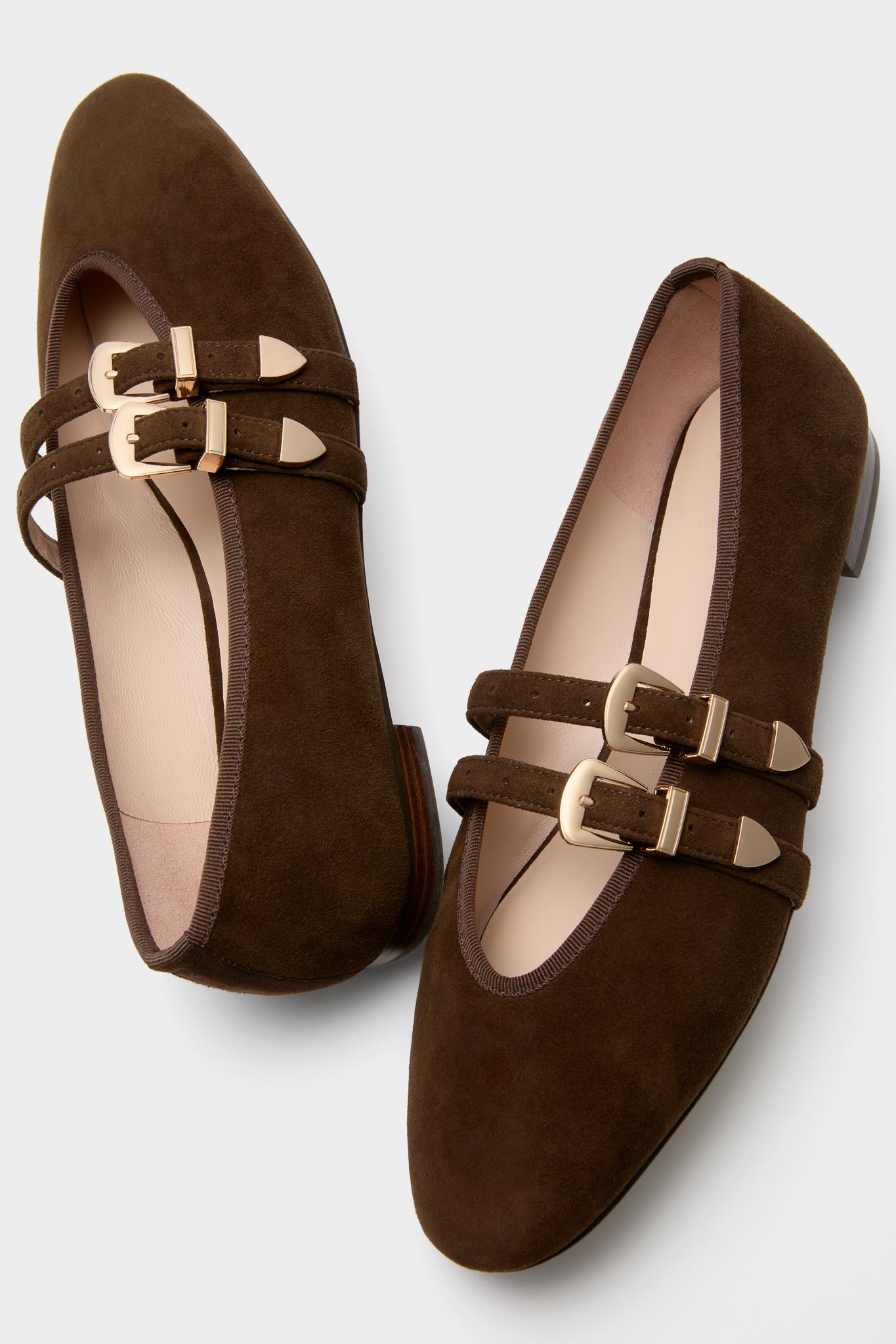 Chocolate Suede Buckle Nina Flats feature classic brown suede with two slim straps and gold-tone buckles, offering an effortless and fun, high-end look.