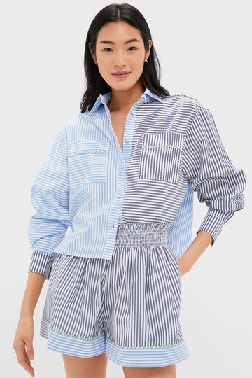 A woman wears a coordinated Hunter Bell Croquet Stripe Hudson Shirt and matching blue and white shorts with green trim.