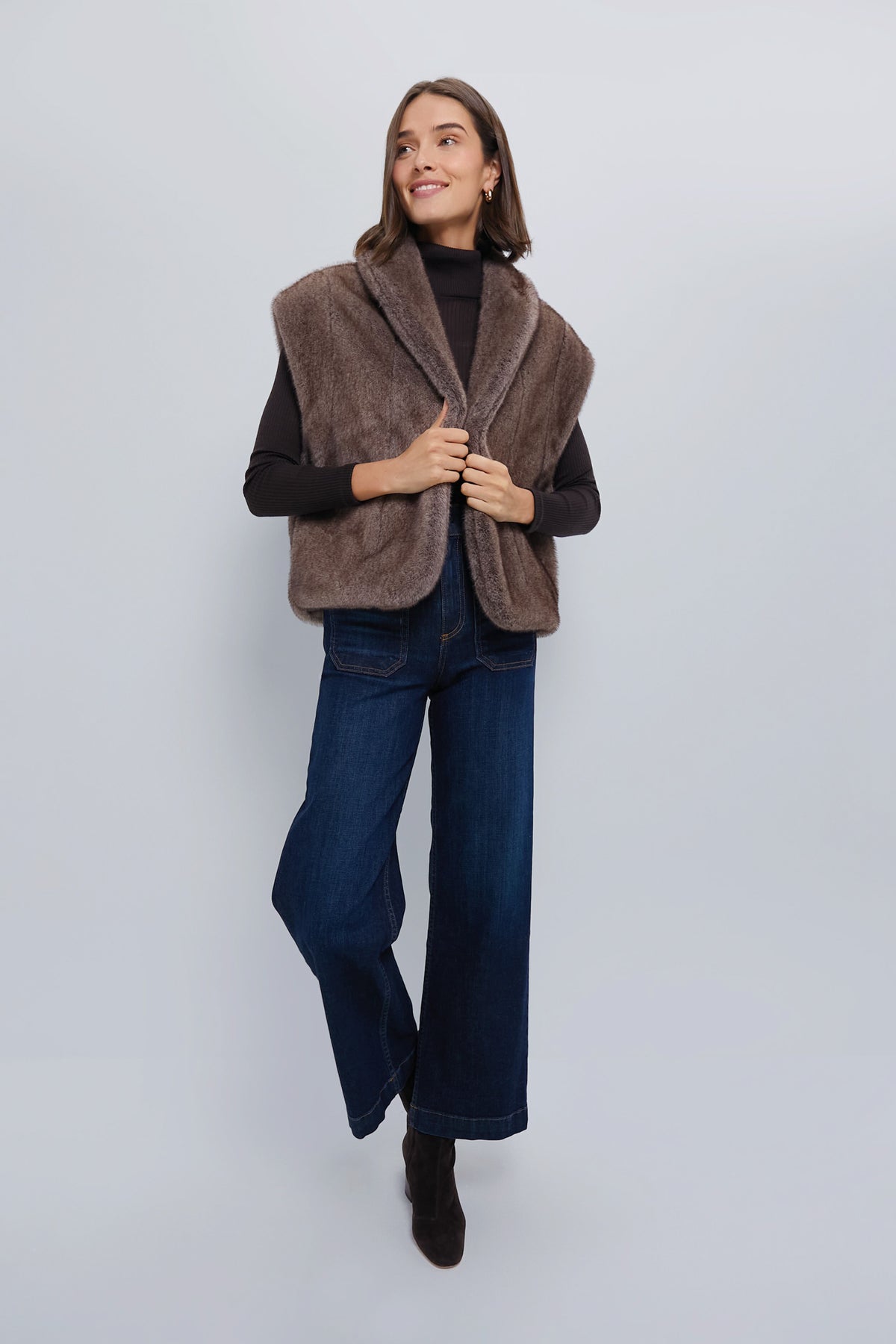 Young woman in an Oversized Aspen Faux Fur Vest, exuding an effortlessly classic, high-end style with a fun and relaxed fit, ideal for versatile layering.