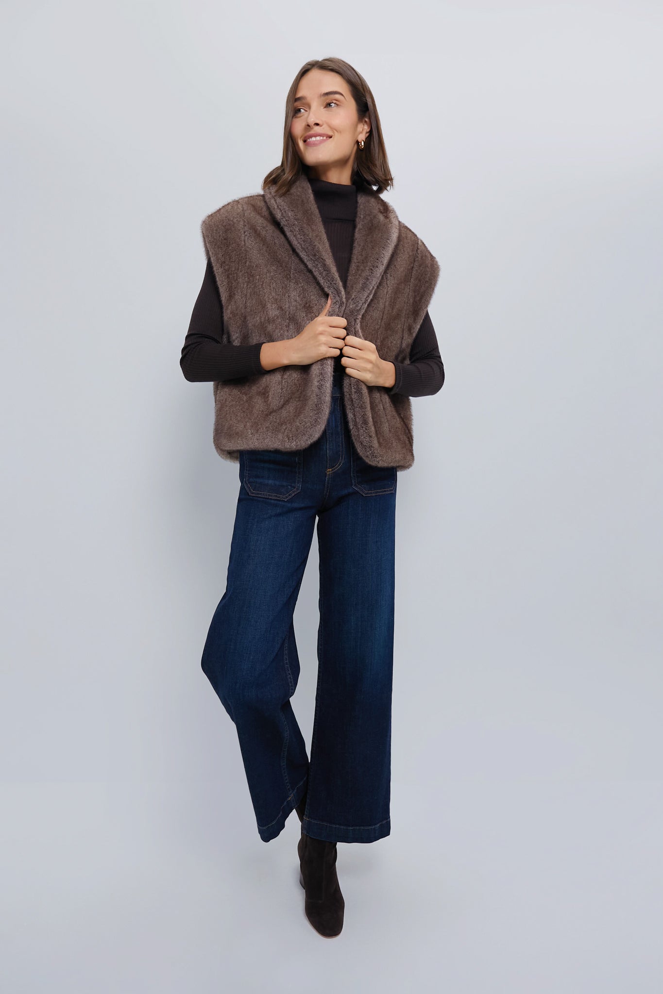 Young woman in an Oversized Aspen Faux Fur Vest, exuding an effortlessly classic, high-end style with a fun and relaxed fit, ideal for versatile layering.