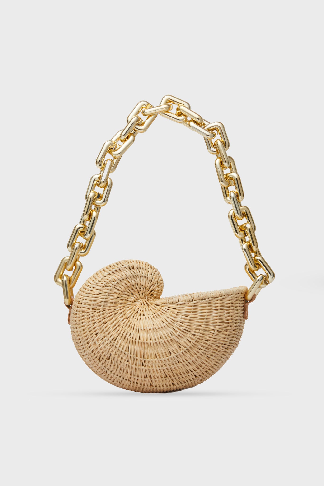 The Poolside shell-shaped rattan bag, inspired by a nautilus, is hand-woven and features a large gold-tone chain strap—making it the perfect unique vacation tote.