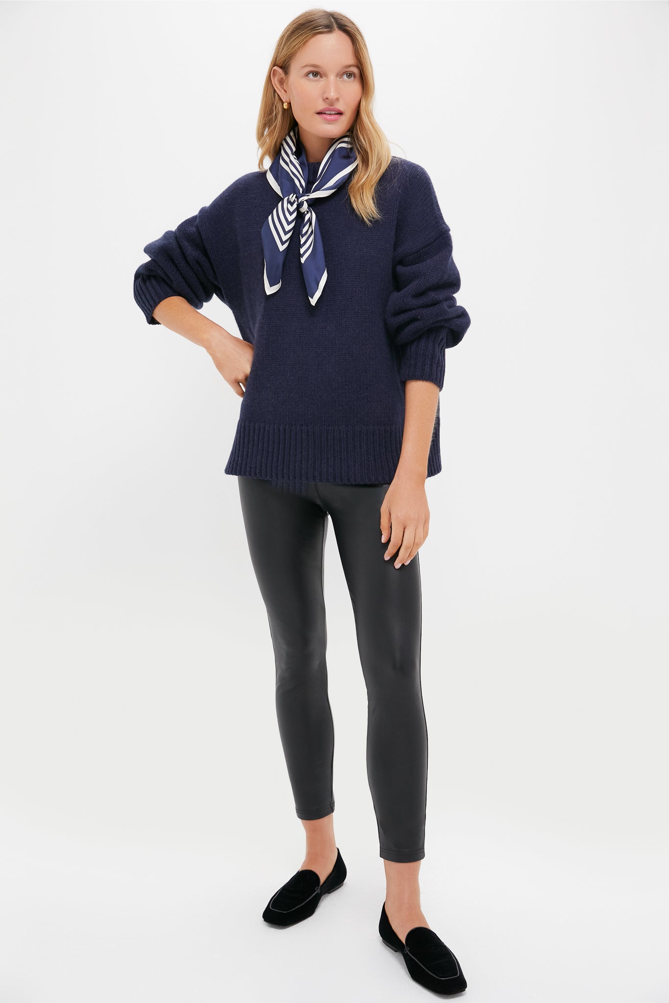 Model in Navy Genevieve Cashmere Wool Blend Crewneck Sweater, paired with slim black leggings and loafers, exuding classic, effortless high-end style with a fun, confident touch.