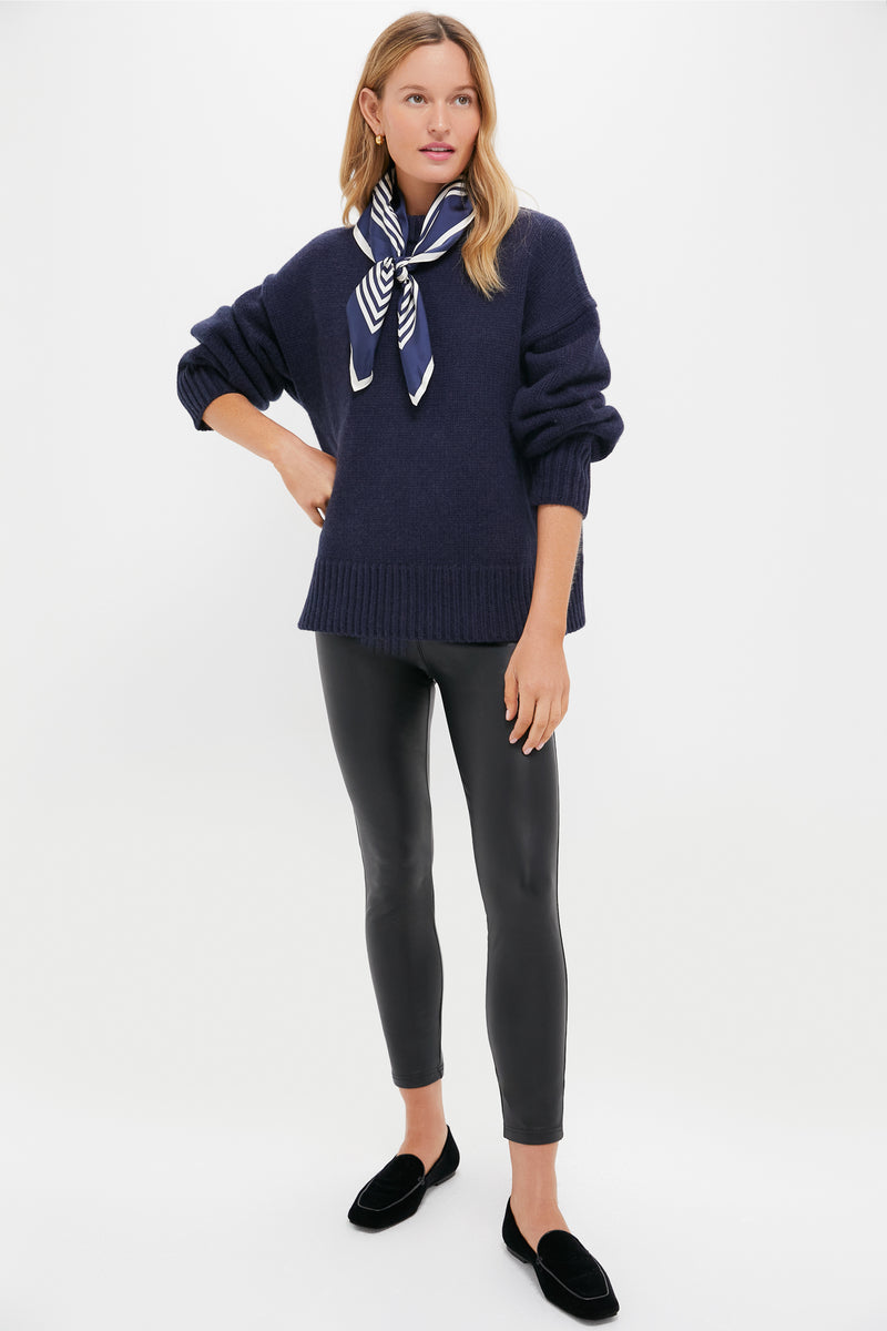 Model in Navy Genevieve Cashmere Wool Blend Crewneck Sweater, paired with slim black leggings and loafers, exuding classic, effortless high-end style with a fun, confident touch.