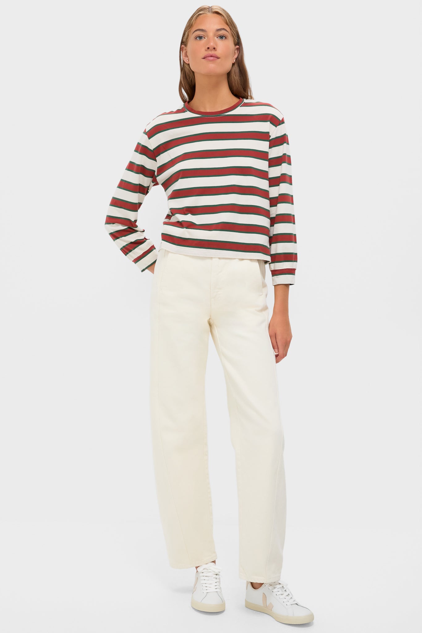 Model wears the classic Cream with Brown Campus Crew tee, featuring effortless Rancho Stripes, paired with high-waisted trousers and sneakers, embodying a fun, high-end casual look.
