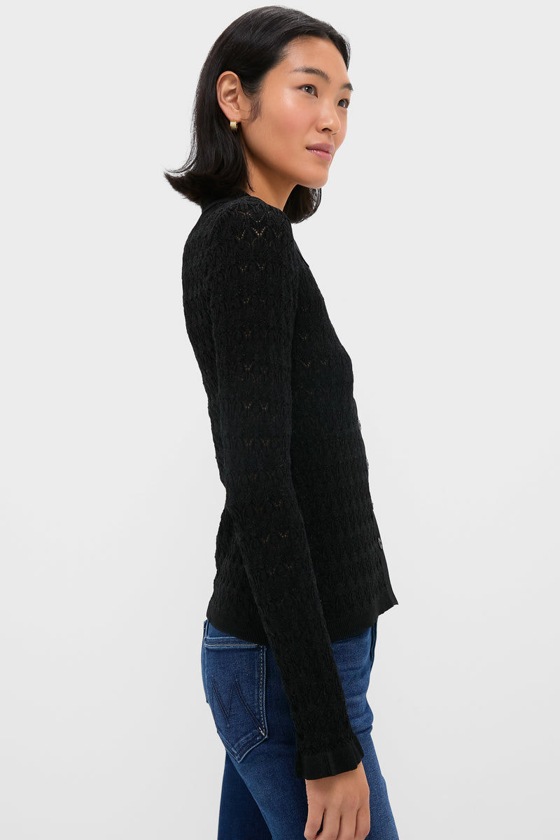 A woman wears a shimmer knit top and blue jeans.