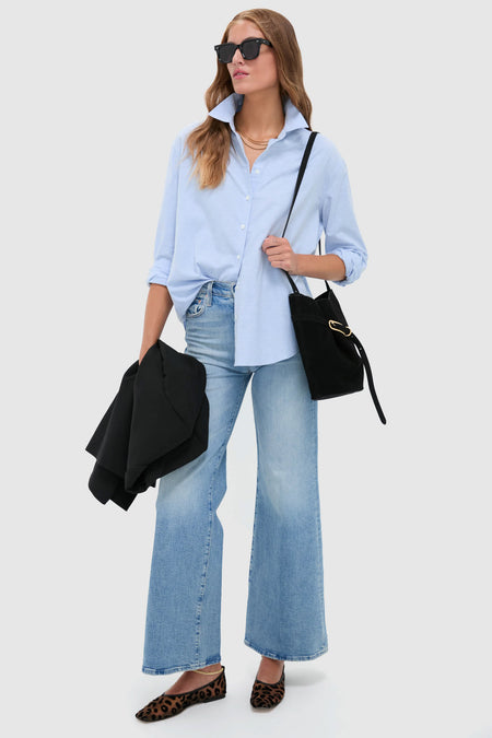 Woman with classic, effortless style carries the high-end Black Suede Belted Bucket Bag, adding fun and sophistication to her outfit with leopard flats and sunglasses.