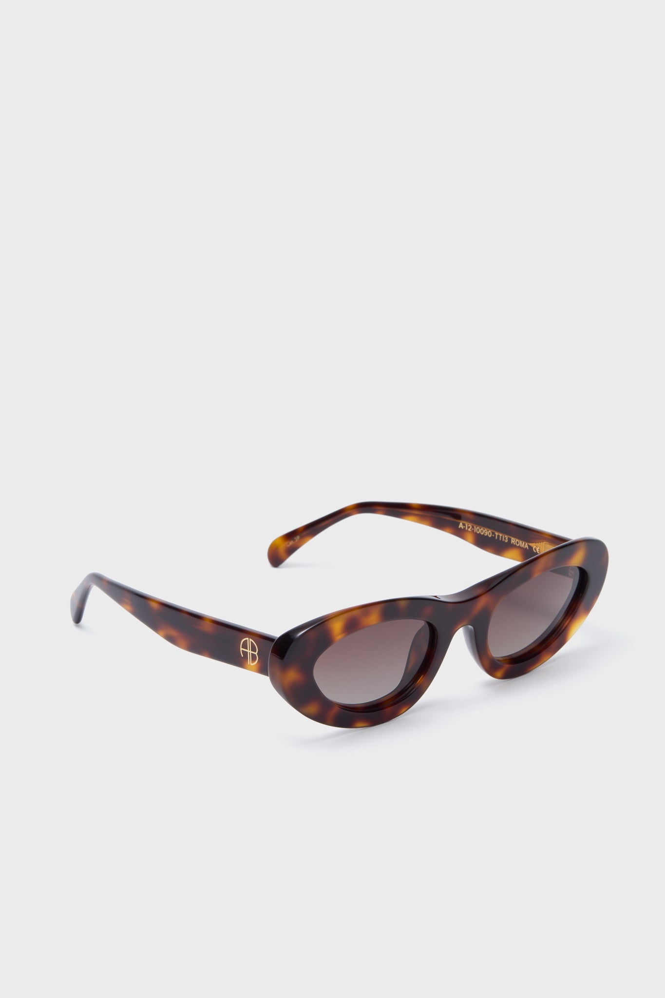 Tortoise Roma Sunglasses feature classic, high-end tortoiseshell cat-eye frames with fun, effortless appeal. Gold-tone accents and dark lenses complete this chic look.