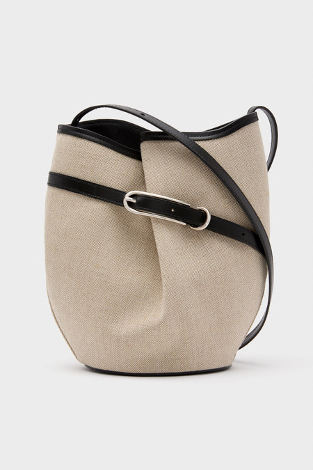 The Liffner beige belted bucket bag features linen canvas, a black leather strap with buckle detail, and Scandinavian-inspired design.